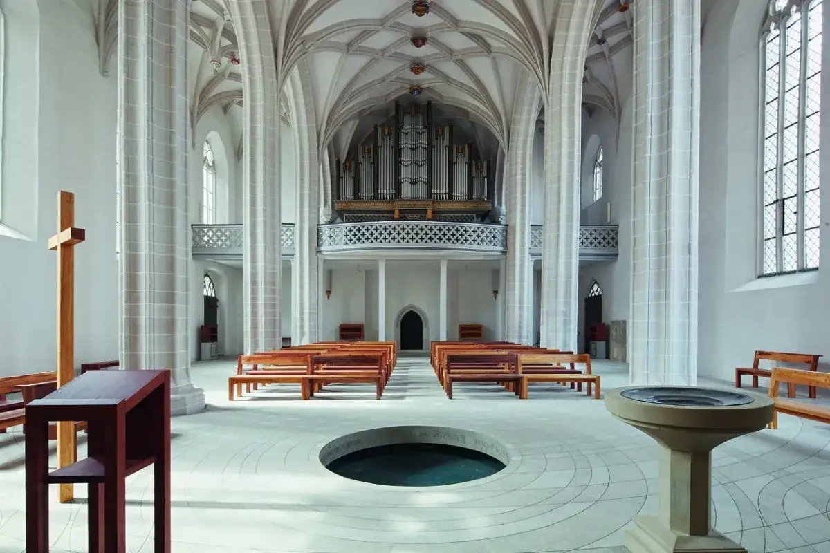 Einladende offene kirchen mit Holzbänken, einem Taufbecken und einer Orgel.