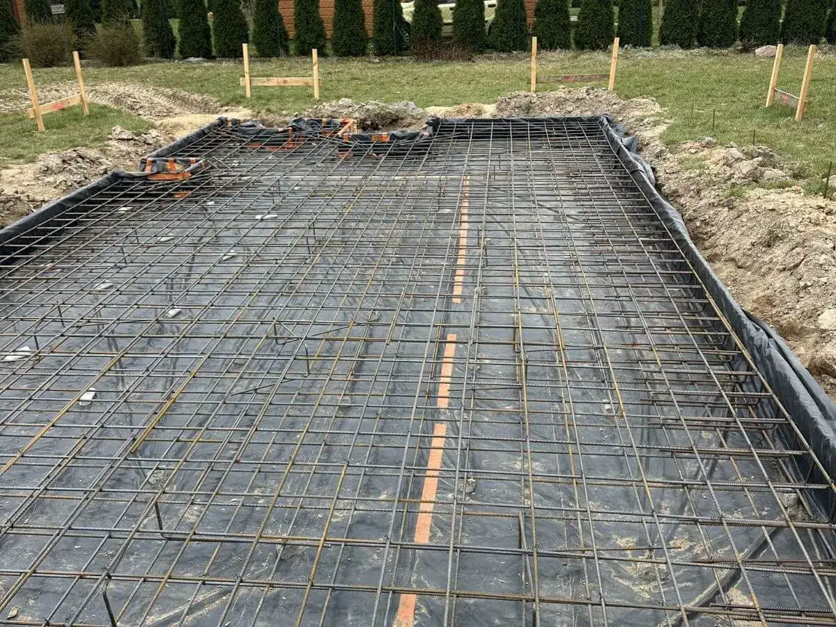 Siatka zbrojeniowa na płycie fundamentowej, gotowa na zalanie betonem. Wybór odpowiedniego **betonu na płytę fundamentową** jest kluczowy dla trwałości budowli.