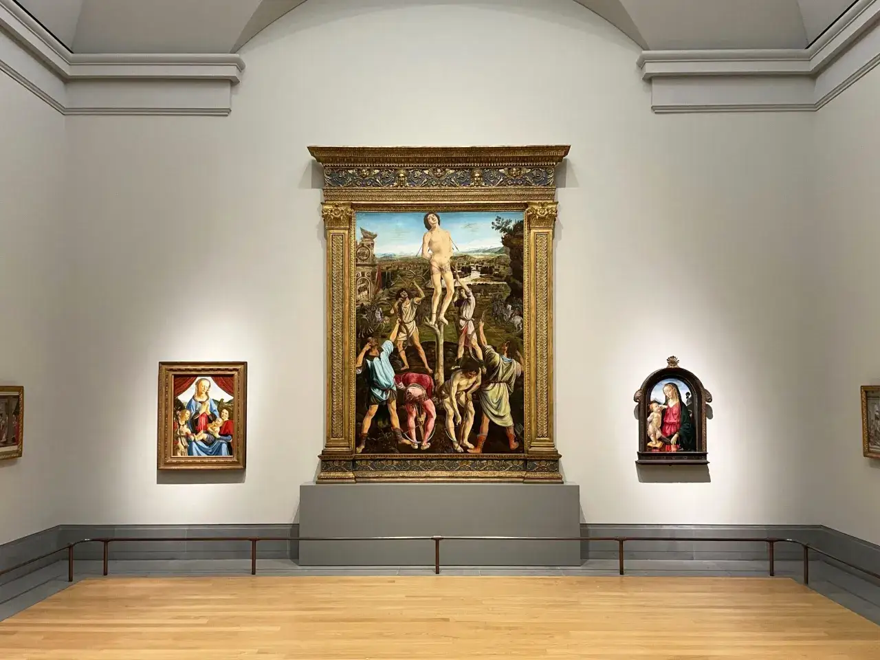 En la National Gallery, cuadros renacentistas adornan las paredes. Destaca una escena con San Sebastián y dos obras más pequeñas.