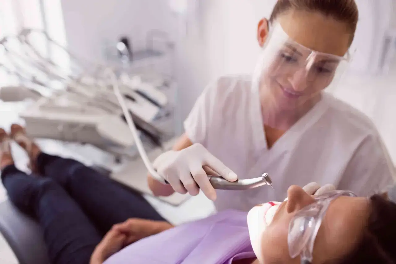 Dentystka wykonuje higienizację zębów pacjentki. Zabieg przed i po wizycie u stomatologa.