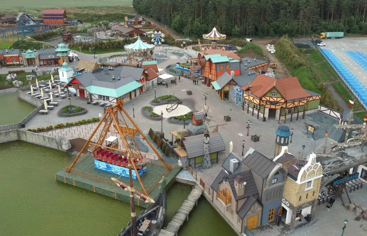 Widok z lotu ptaka na park rozrywki Hossoland z karuzelami, kolejką górską i atrakcjami wodnymi.