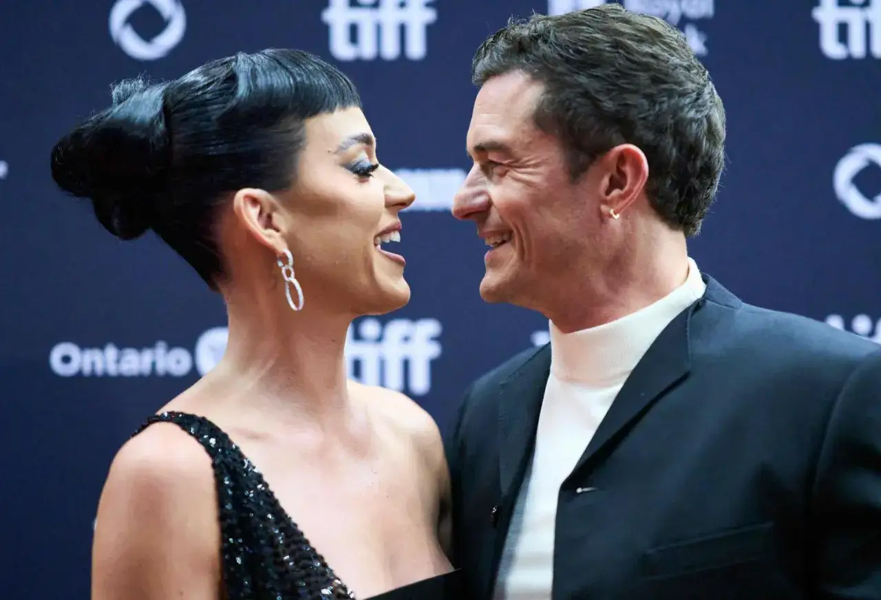 Katy Perry i Orlando Bloom patrzą na siebie z uśmiechem, w tle logo TIFF i napis Ontario.