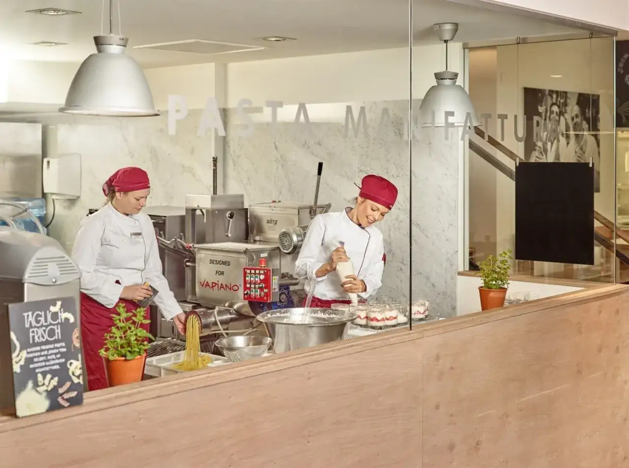 Kucharze w Vapiano przygotowują świeży makaron i desery.