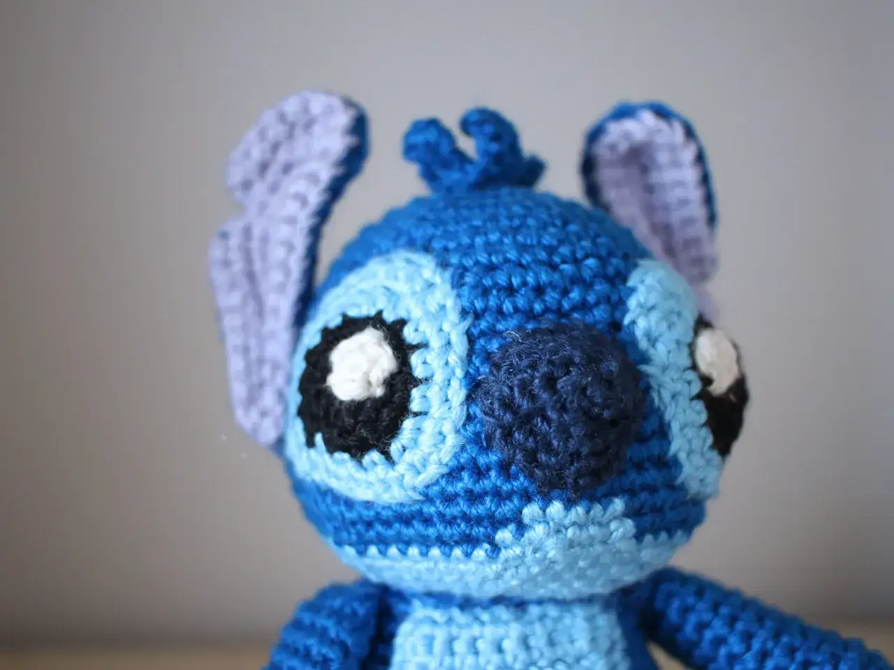 Un adorable Stitch de ganchillo, hecho paso a paso, con sus grandes ojos negros y orejas moradas.