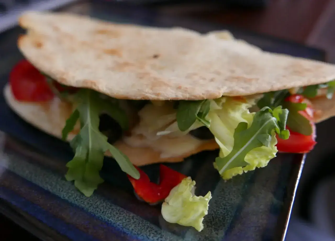 Pyszna piadina z rukolą, pomidorkami i sałatą. Idealna na szybki lunch.