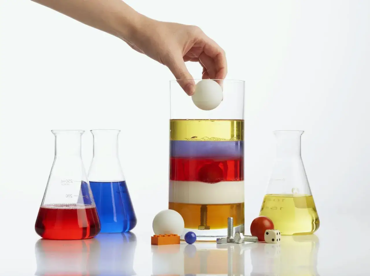 Experiment zur Dichte berechnen: Flüssigkeiten schichten sich nach Dichte. Ein Ei schwebt auf verschiedenen Ebenen.
