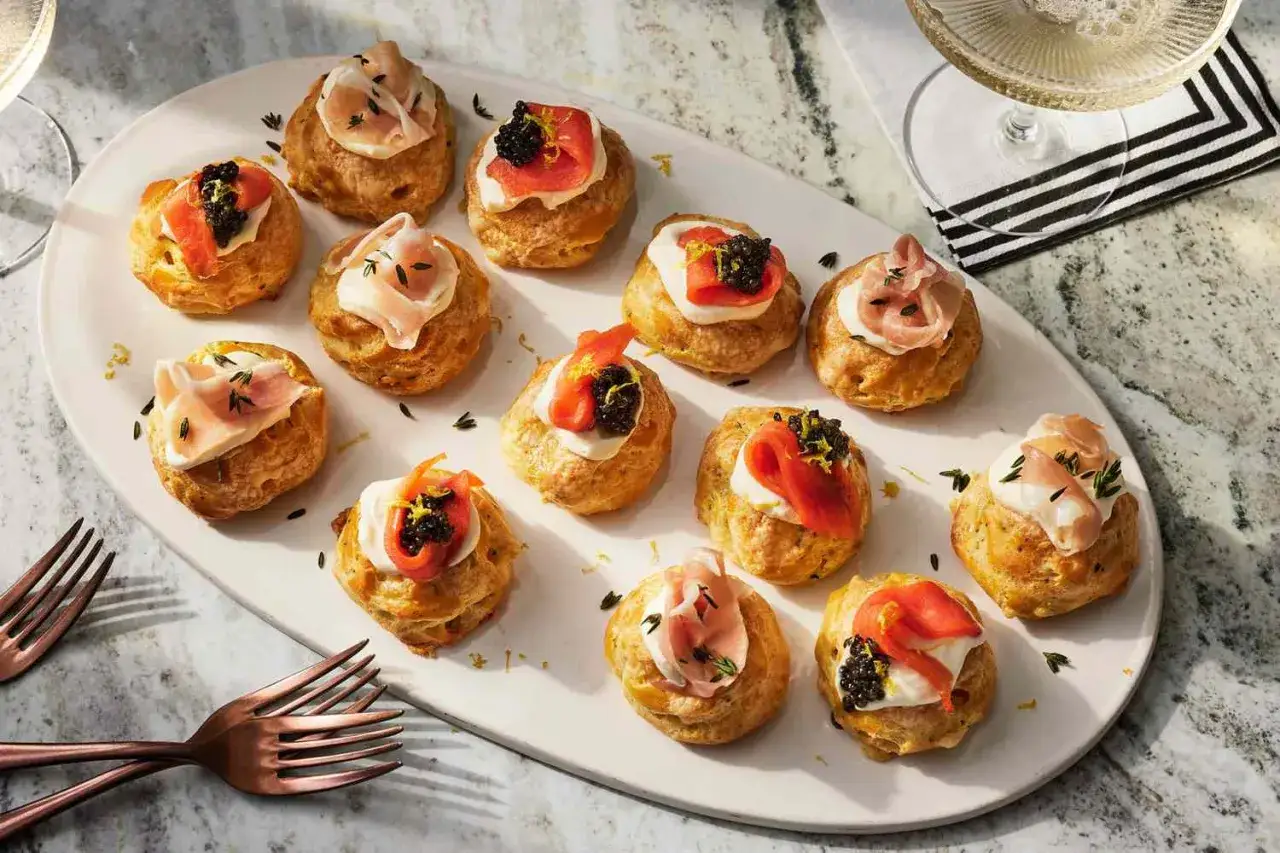 Små, eleganta tilltugg till bubbel: puffar fyllda med kräm, toppade med lax, kaviar eller prosciutto. Perfekt för festen!