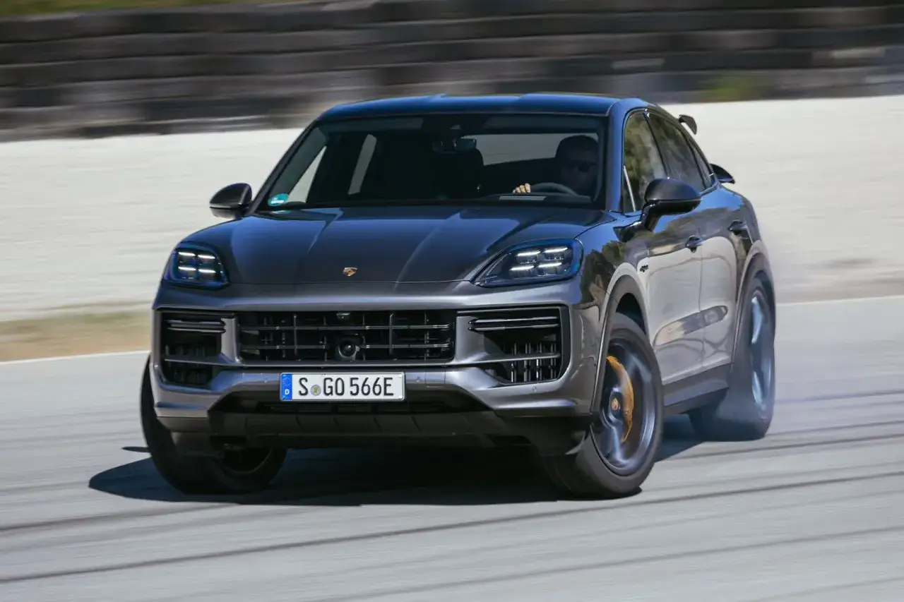 Porsche Cayenne Turbo na torze, w zakręcie, z dymem spod kół. Kierowca w okularach.
