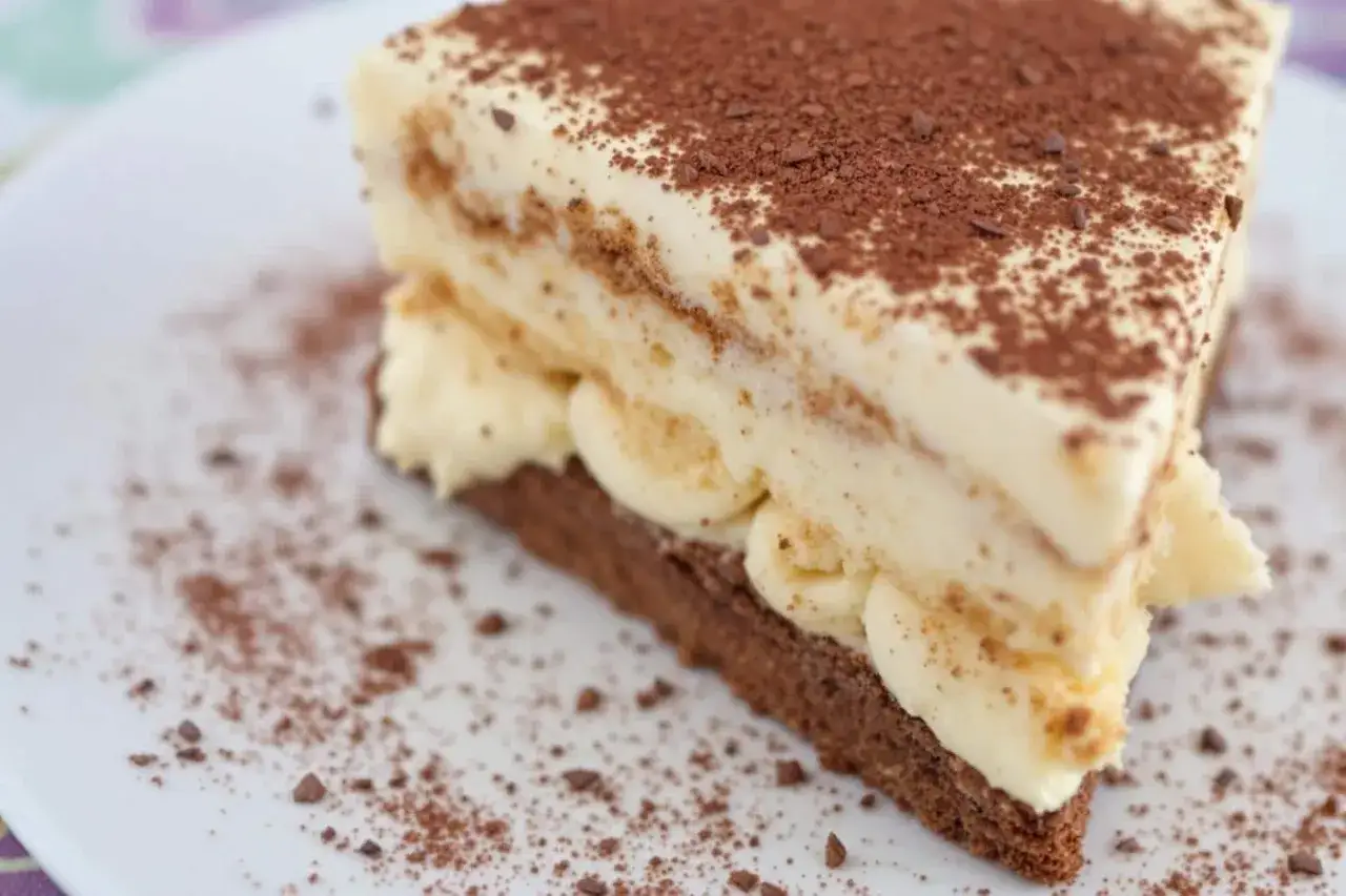 Tranche de tiramisu onctueux, saupoudrée de cacao. Combien de temps au frigo pour qu'il soit parfait ?