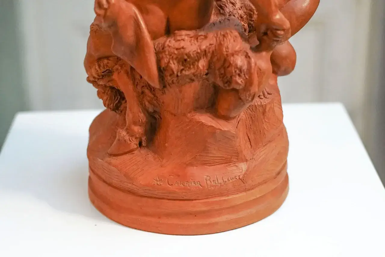 Détail d'une sculpture en terre cuite signée A. Carrier-Belleuse, représentant une scène mythologique.