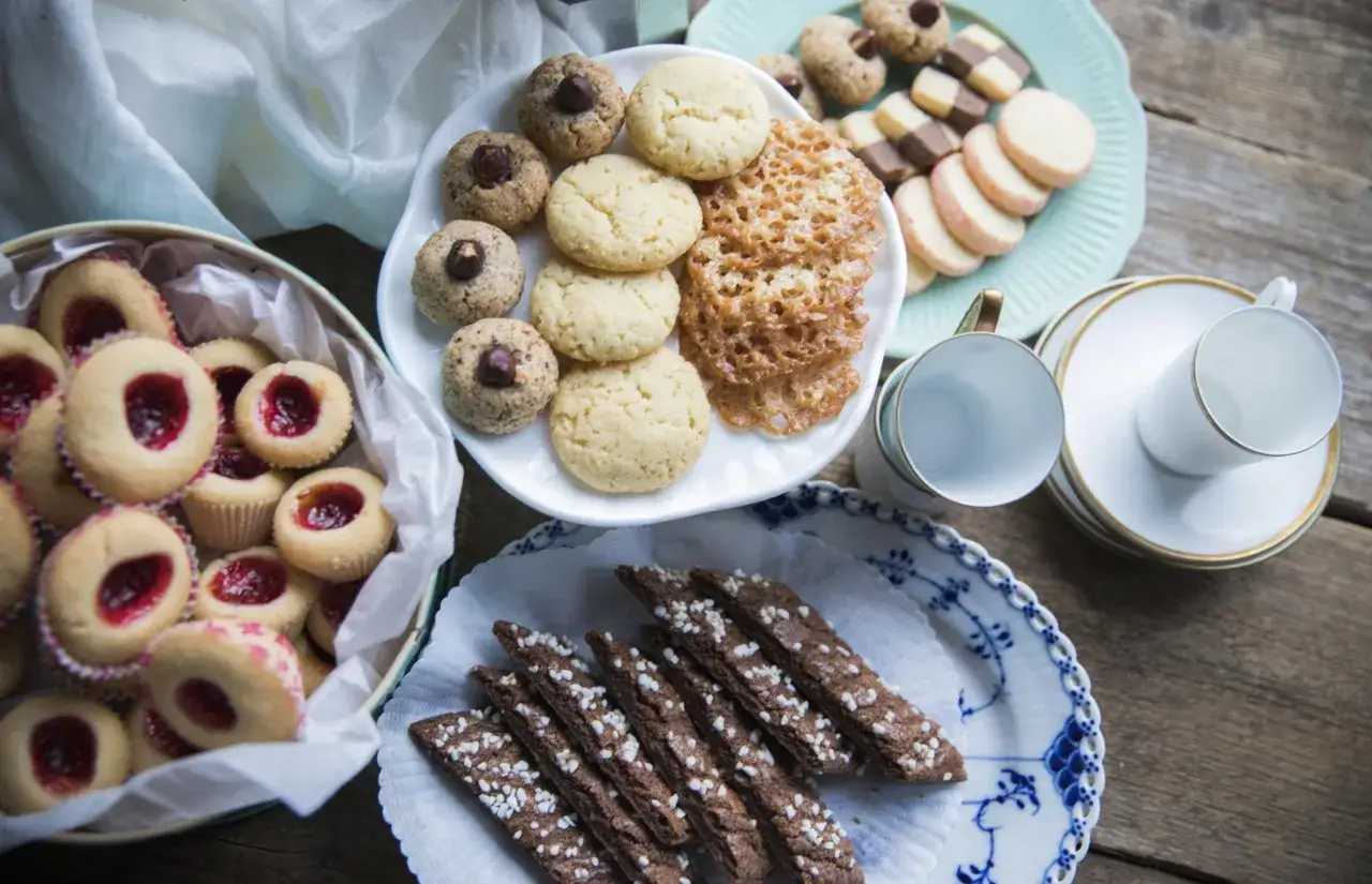 En h&auml;rlig uppdukning med sju sorters kakor recept, inklusive syltkakor, n&ouml;tkakor och chokladkakor, redo att avnjutas.