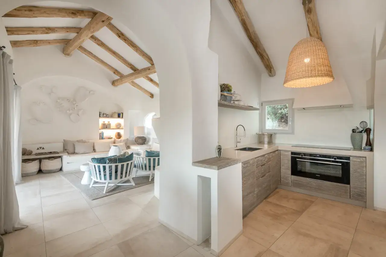 Cucina moderna con isola, elettrodomestici a vista e travi in legno a vista. Chiediti quanto costa rifare una cucina cos&igrave;.