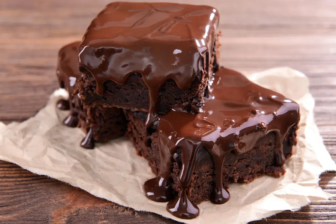 Słodkie brownie polane obficie płynną czekoladą, idealne, by pokazać, jak polać ciasto czekoladą.