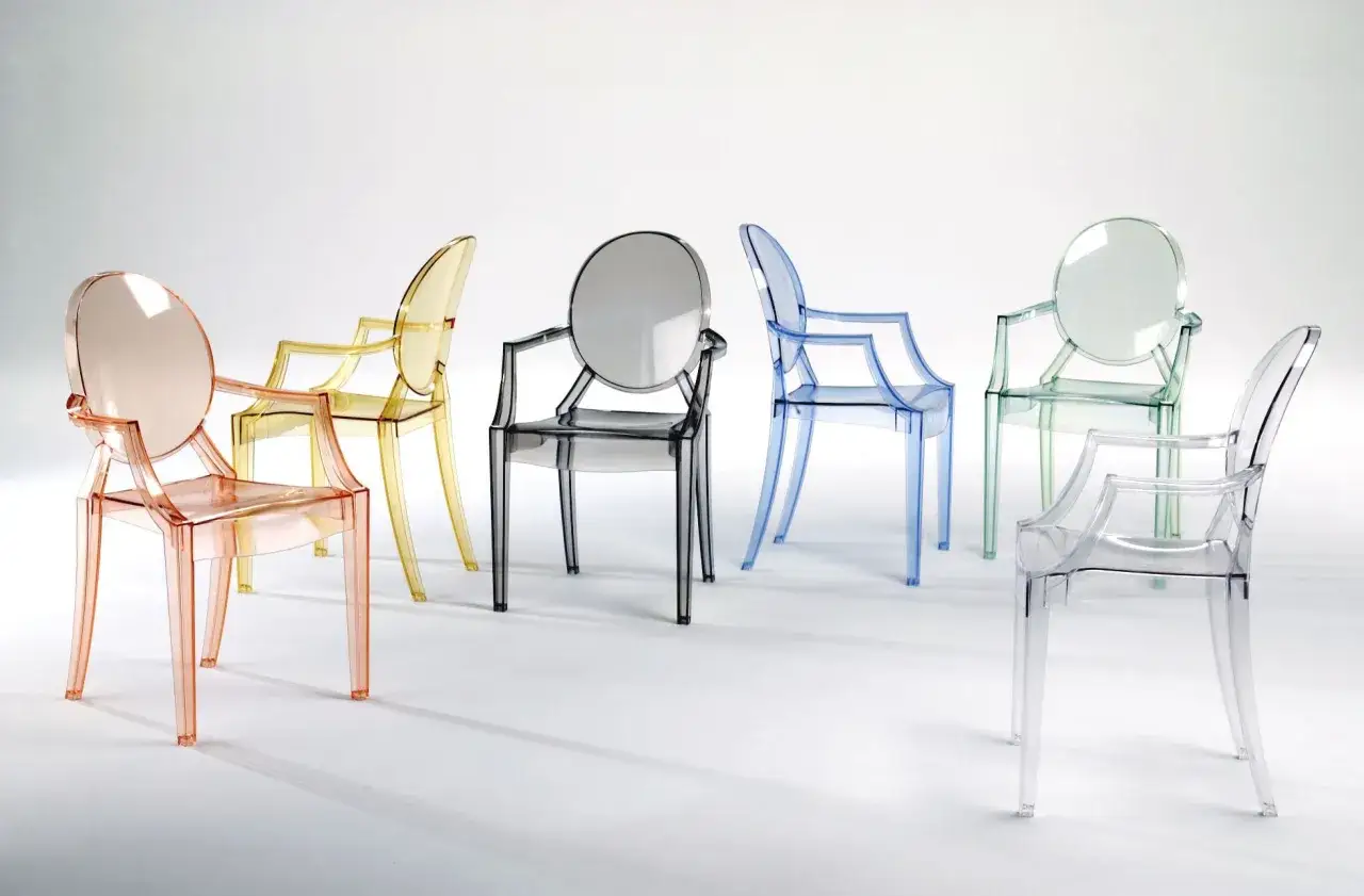 Seis butacas de dise&ntilde;o famosas transparentes en tonos rosa, amarillo, gris, azul, verde y transparente, dispuestas sobre fondo blanco.