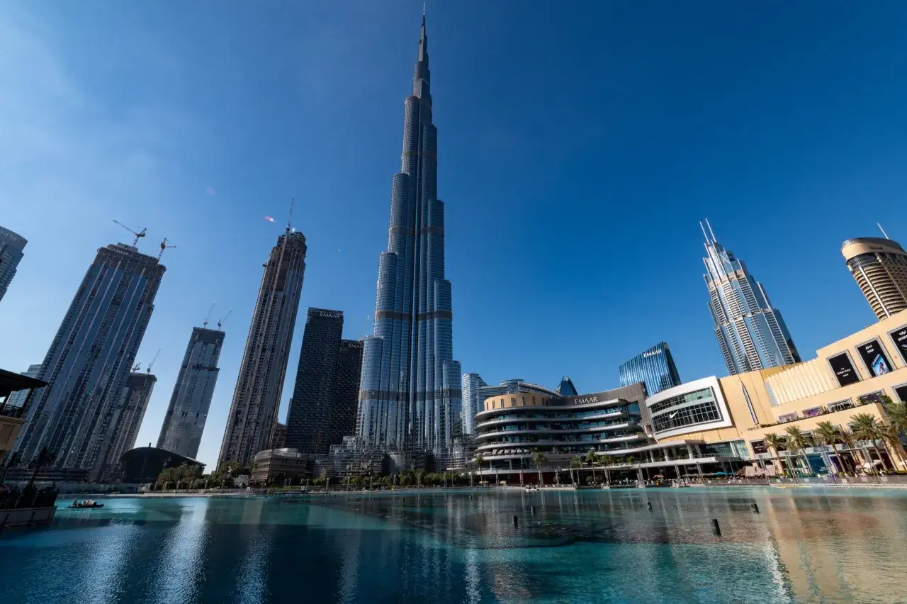 Dubaj, majestatyczny Burj Khalifa góruje nad nowoczesnym krajobrazem miasta, odbijając się w spokojnej tafli wody.