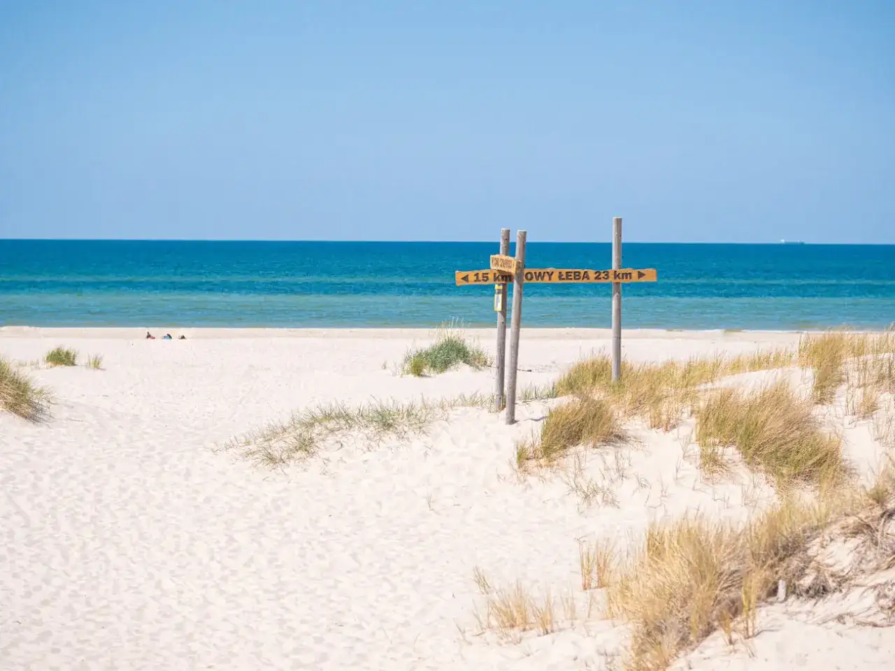 Piasek, morze i drogowskaz do Łeby – to musi być najpiękniejsza plaża w Polsce. Słońce, spokój i błękit nieba.