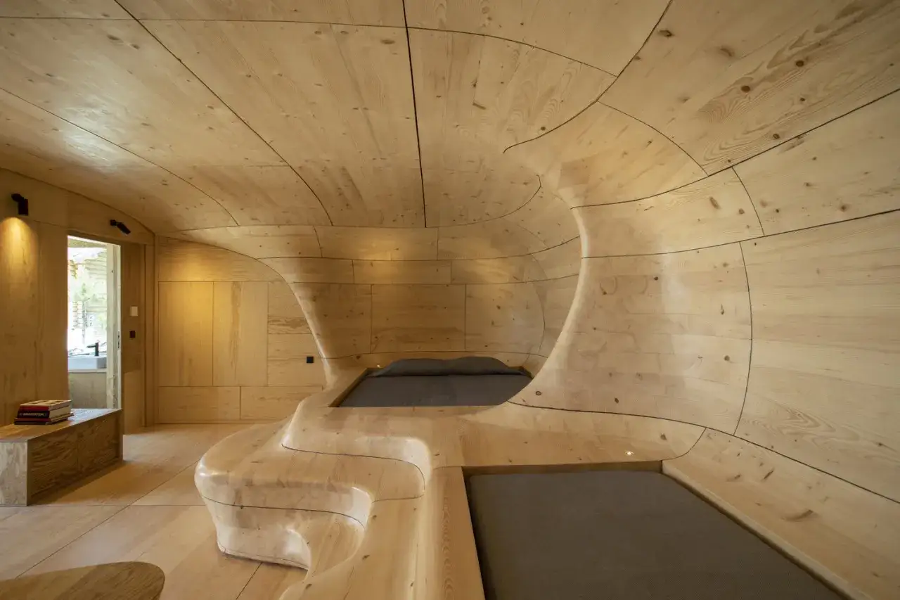 Interior de una casa cueva con camas integradas en la madera, creando un espacio org&aacute;nico y acogedor.