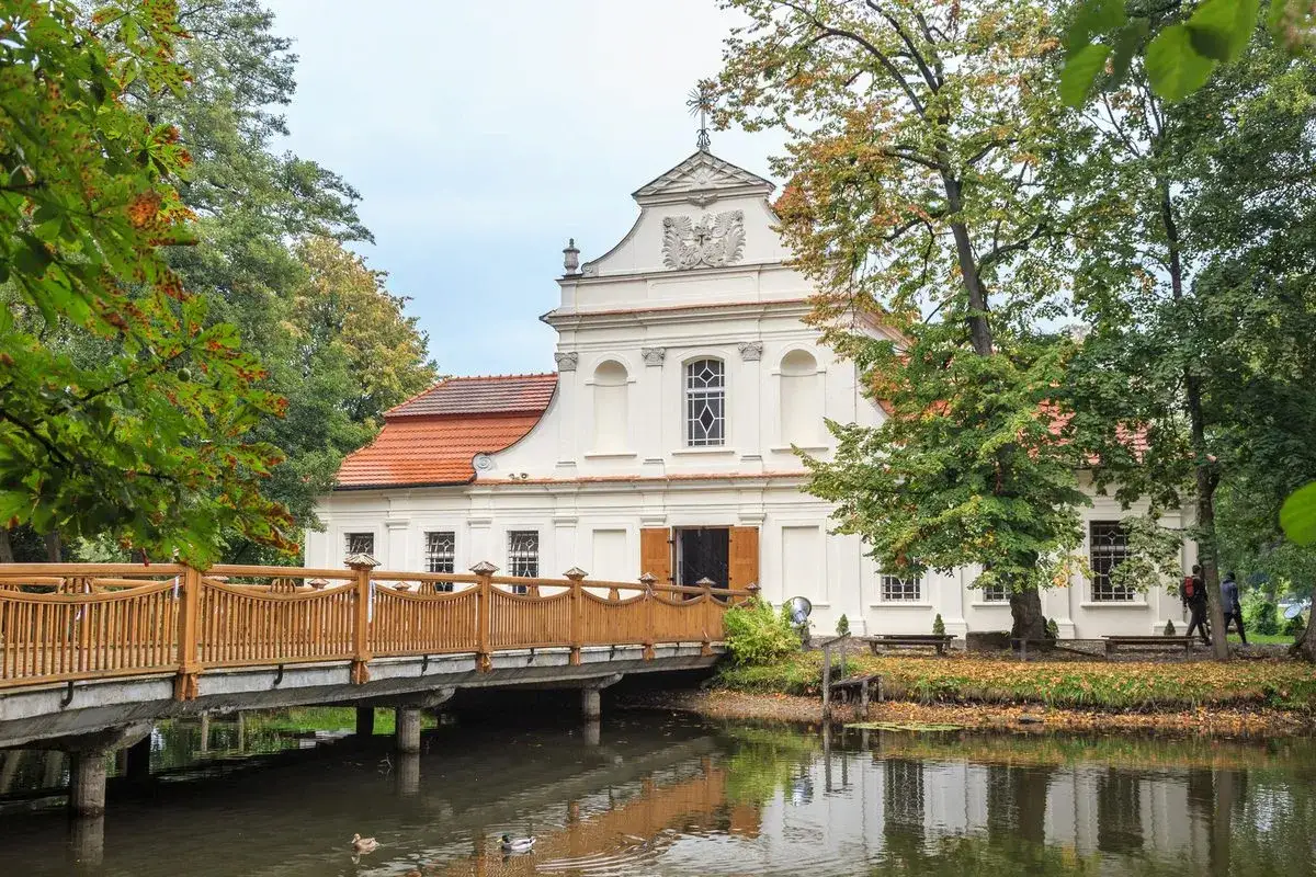 Pałac w Koryznach, jedna z atrakcji okolic Zamościa, otoczony jesienną zielenią i wodą.