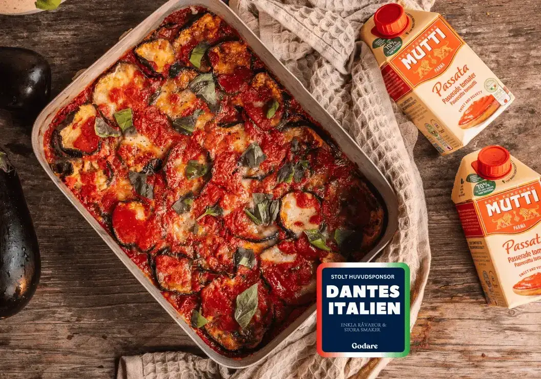 En ugnsbakad auberginegratäng med tomatsås och ost, en klassisk rätt inom cucina povera. Bredvid syns Mutti passata.