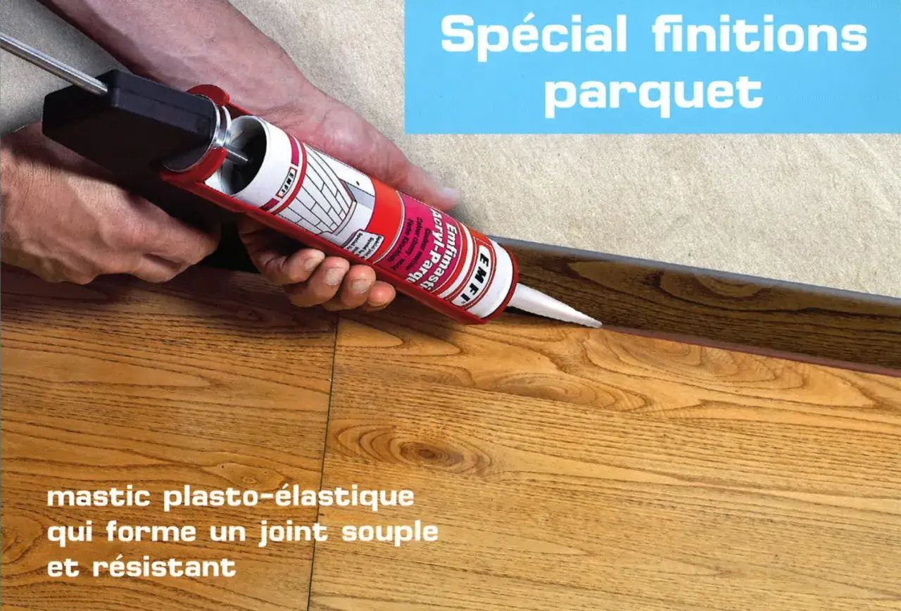 Application de mastic pour combler l'espace entre mur et parquet stratifié. Un joint souple et résistant pour des finitions parfaites.