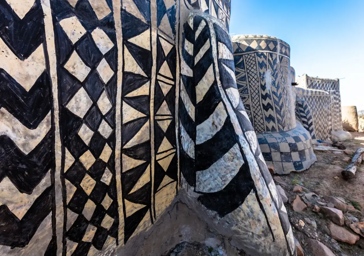 Tradycyjne chaty w Burkina Faso ozdobione geometrycznymi wzorami w czerni i bieli.