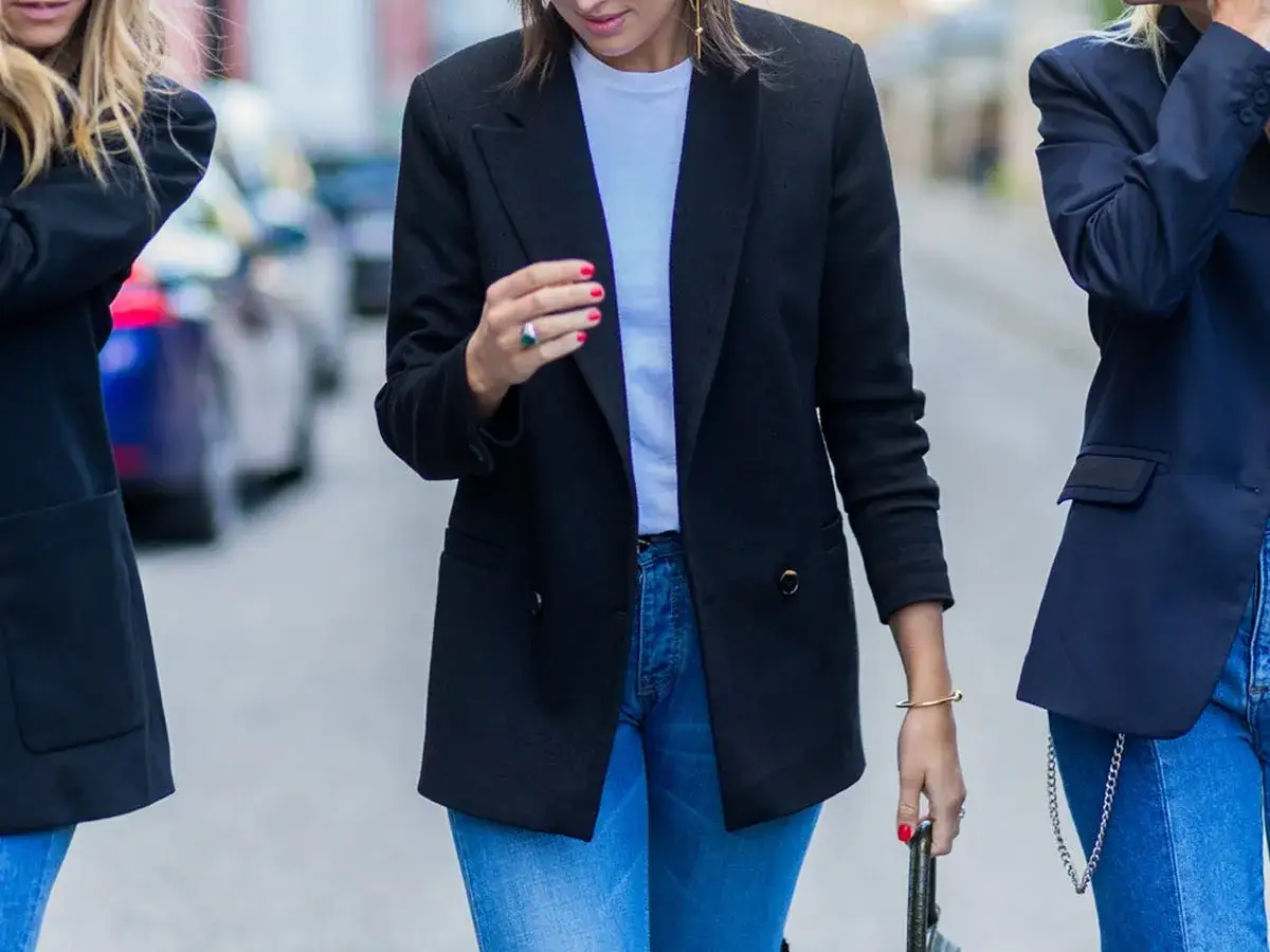 Diverse tipologie di giacche eleganti indossate da donne con jeans.