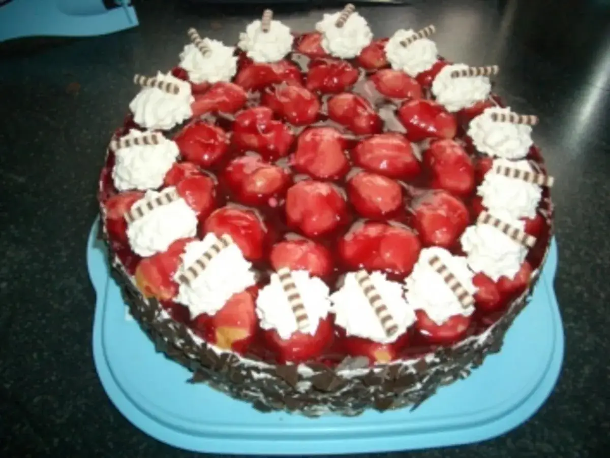 Eine k&ouml;stliche Windbeuteltorte mit frischen Erdbeeren und Sahnetupfern, verziert mit Schokost&uuml;ckchen. Ein Traum f&uuml;r jeden Kuchenliebhaber!