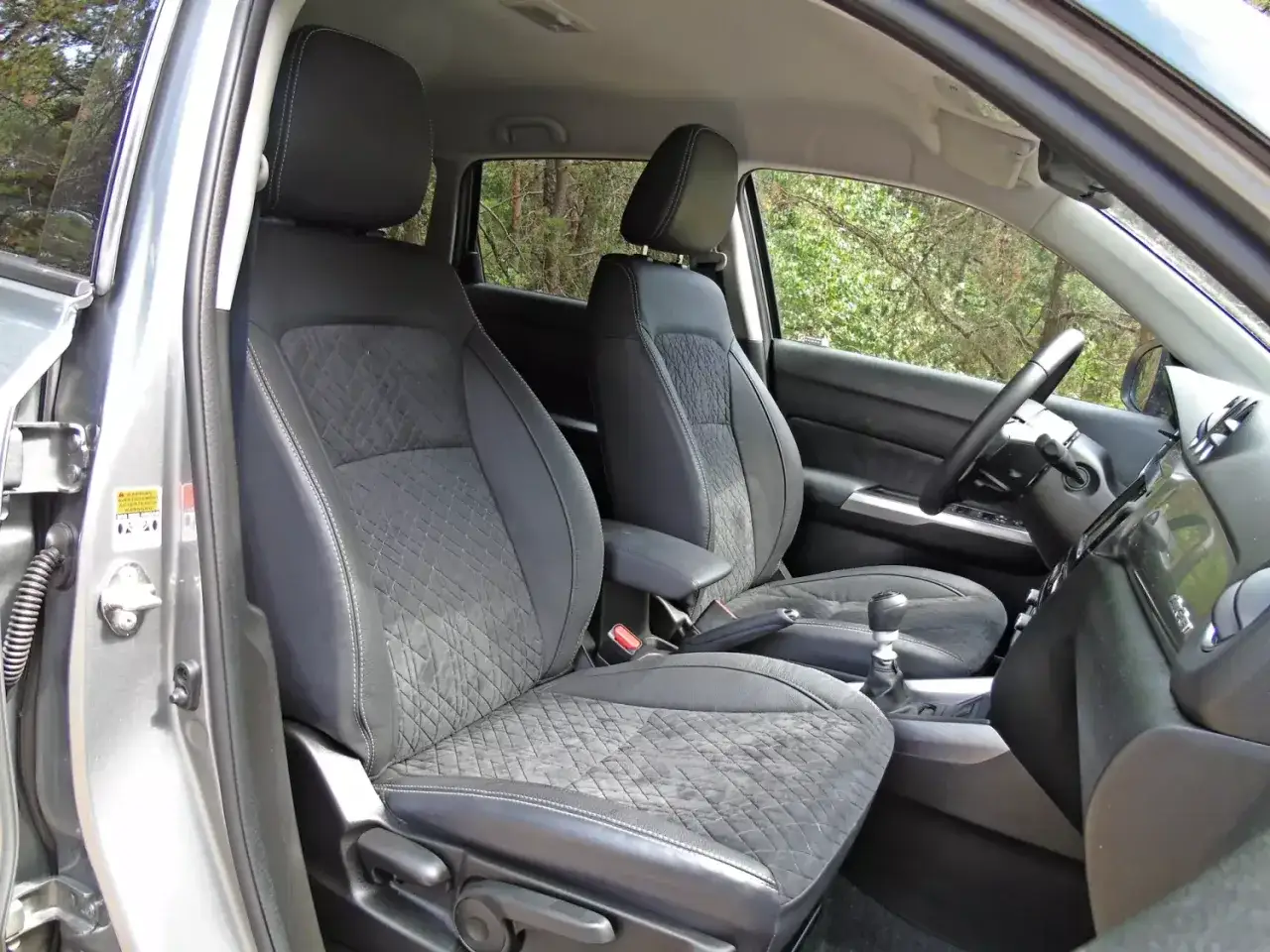 Wnętrze Suzuki Vitara z wygodnymi, pikowanymi fotelami. Wiele osób chwali sobie te **suzuki vitara opinie** o komforcie jazdy.