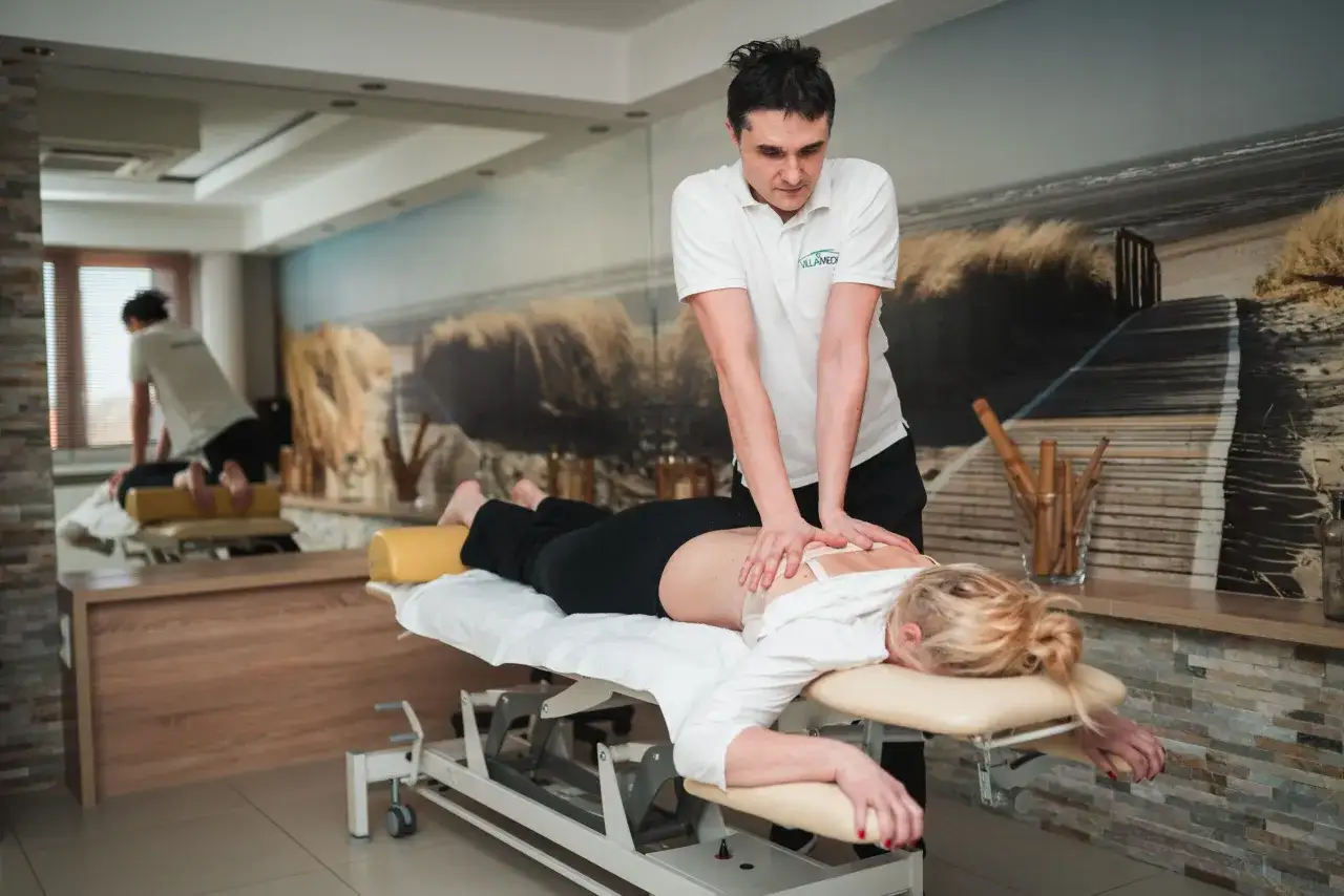 Osteopata wykonuje masaż pleców pacjentki. Dowiedz się, co to jest osteopata i jak może pomóc.