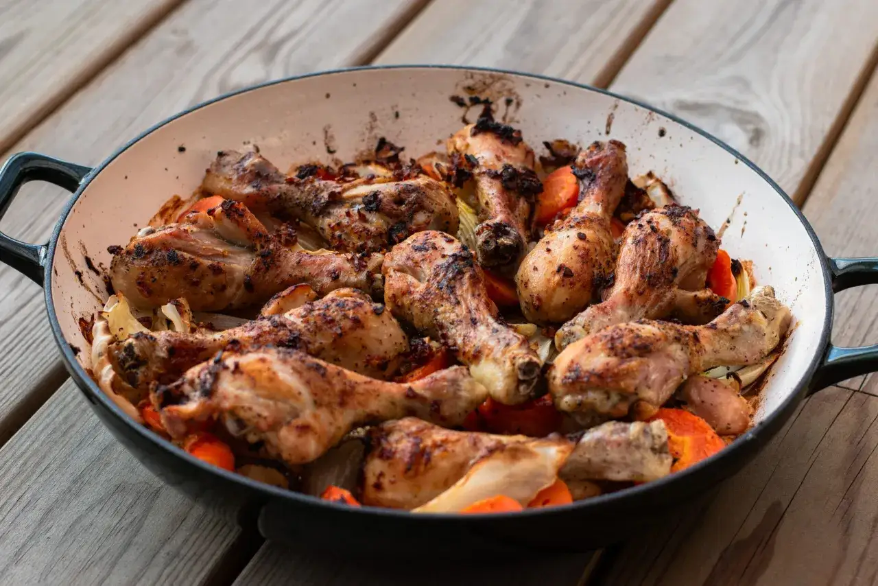 Ugnsbakade kycklingben med rotfrukter i en gjutj&auml;rnspanna. Perfekt kycklingben temperatur f&ouml;r en saftig och god m&aring;ltid.