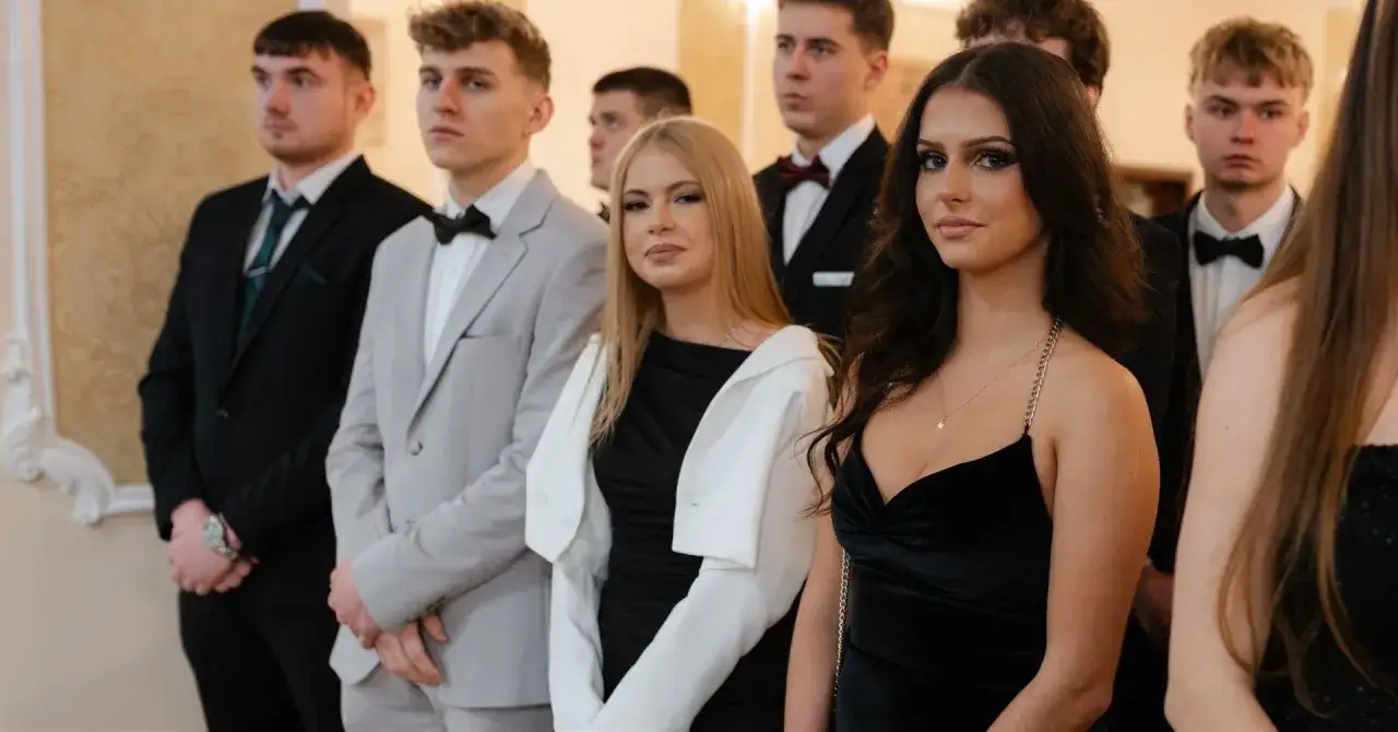 Młodzi ludzie w eleganckich strojach, zastanawiają się, czy w szkole zaocznej jest studniówka.