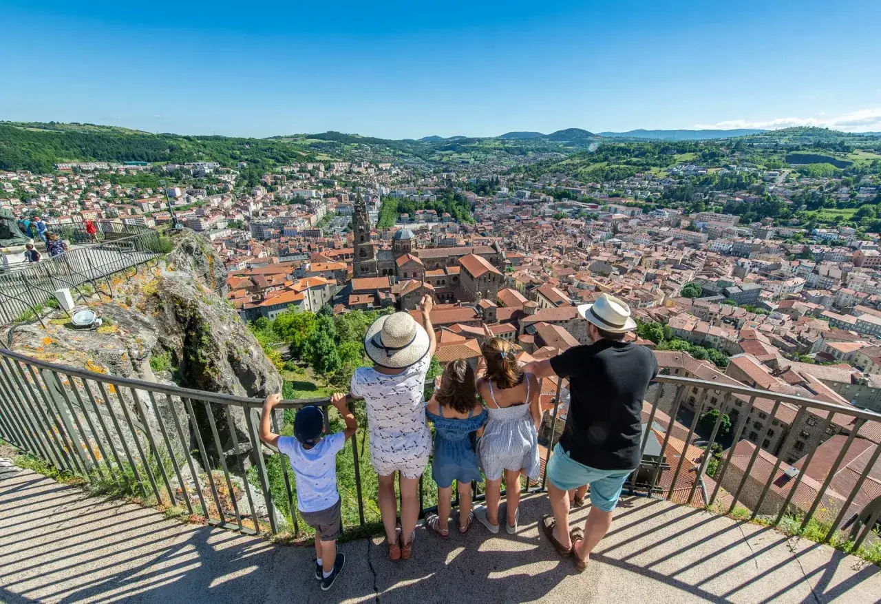 Famille profitant de la vue panoramique sur Le Puy-en-Velay, une belle journée pour visiter la ville à pied.