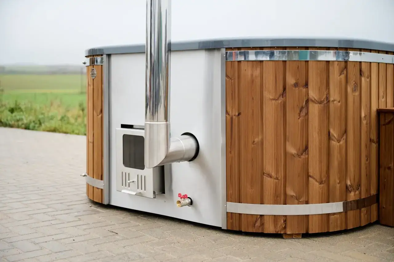 En modern badtunna hybrid med träpanel och integrerad eldstad. Perfekt för avkoppling utomhus.