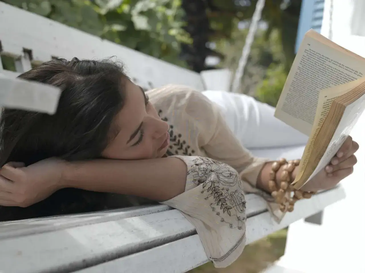 Joven leyendo un libro en un banco, ideal para encontrar libros para adolescentes de 13 años.