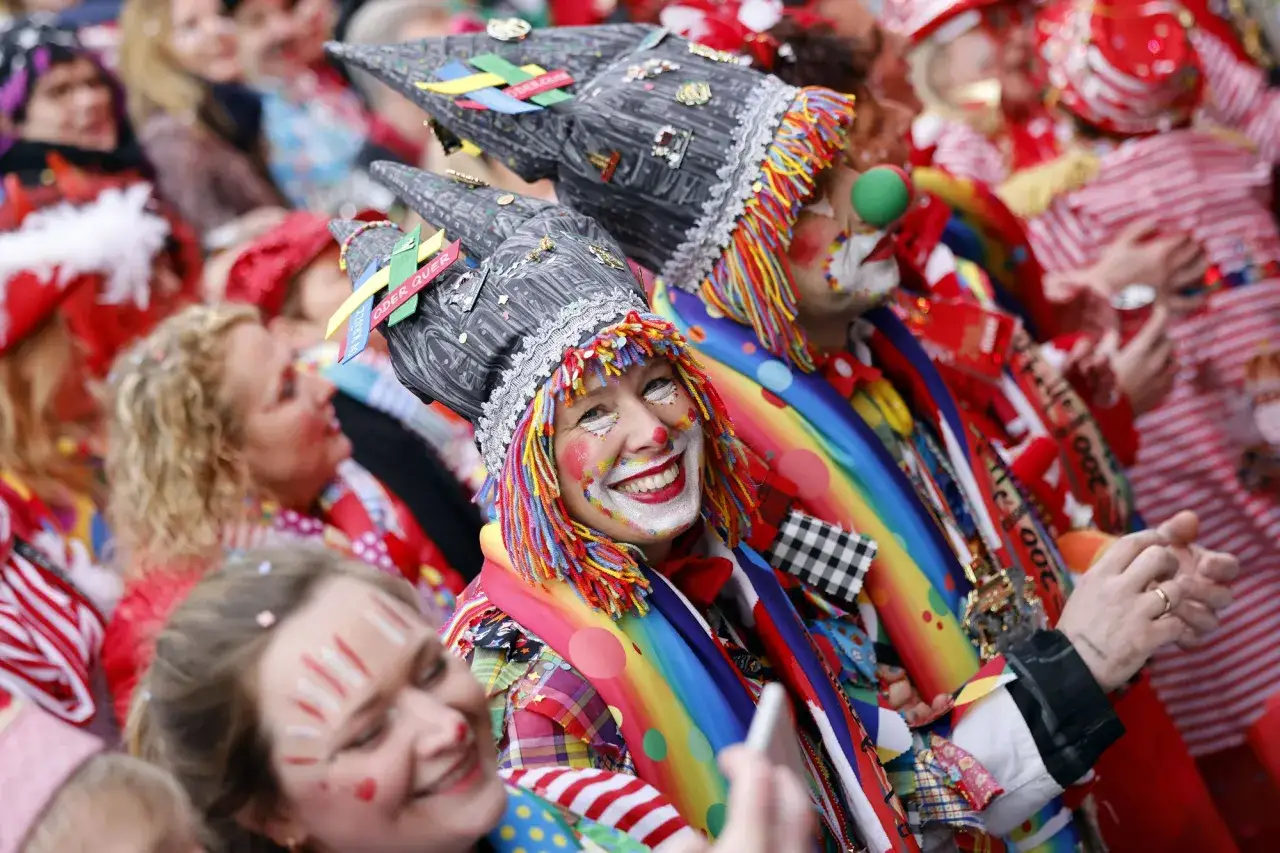 Menschen in bunten Kost&uuml;men und Clown-Make-up feiern ausgelassen. Die fr&ouml;hliche Stimmung bei diesen jecken Tagen ist ansteckend.