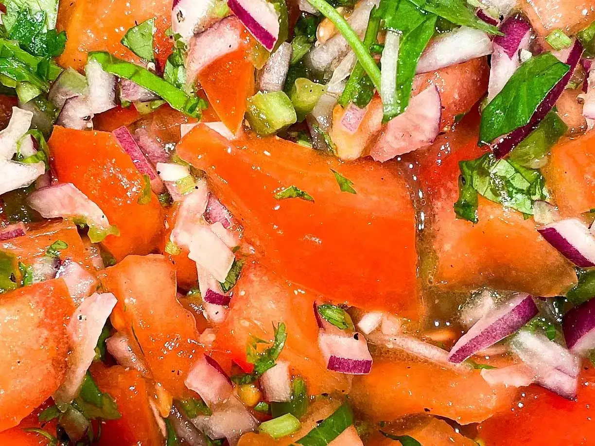 En närbild av färsk pico de gallo med saftiga tomater, rödlök och koriander. Perfekt till tacos!