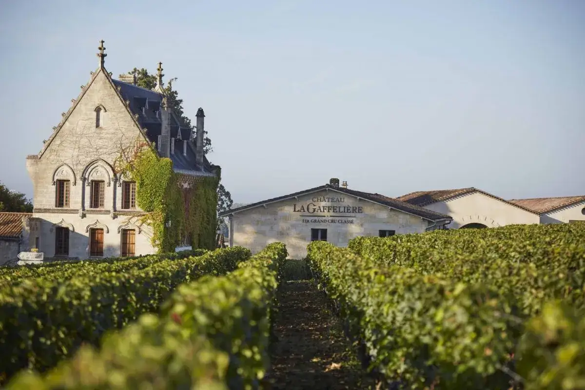 Le **Ch&acirc;teau La Gaffeli&egrave;re**, un Premier Grand Cru Class&eacute;, se dresse fi&egrave;rement au milieu de ses vignobles verdoyants sous un ciel clair.