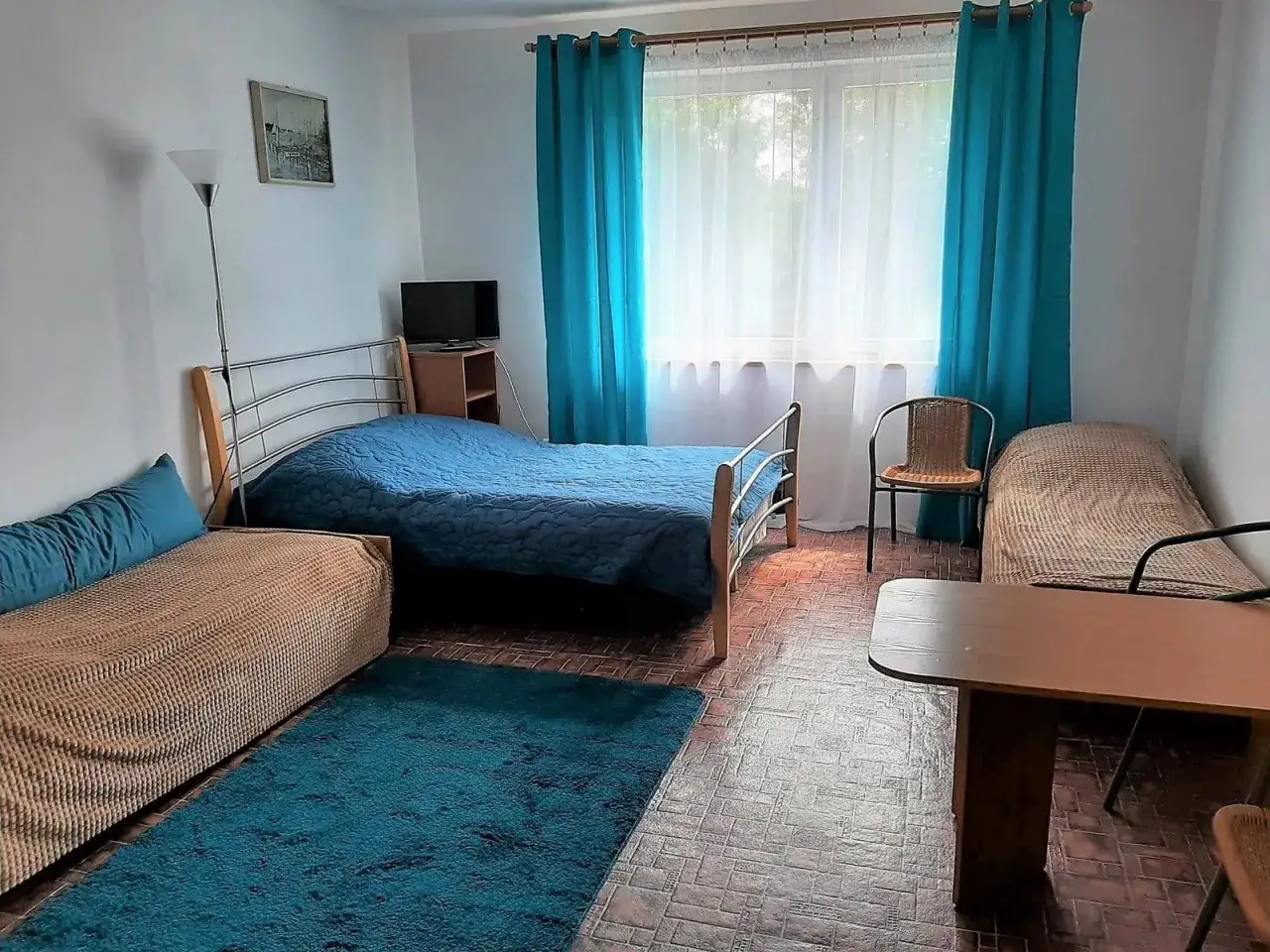 Pobierowo domki 4 osobowe: pokój z dwoma łóżkami, kanapą, stolikiem i telewizorem. Idealne miejsce na wakacje.