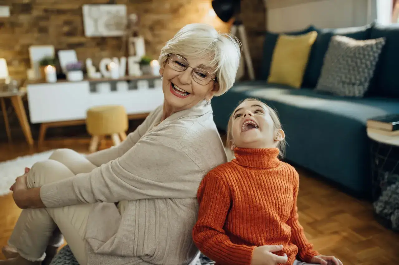 Abuela paterna celosa r&iacute;e con su nieta, compartiendo un momento de alegr&iacute;a.