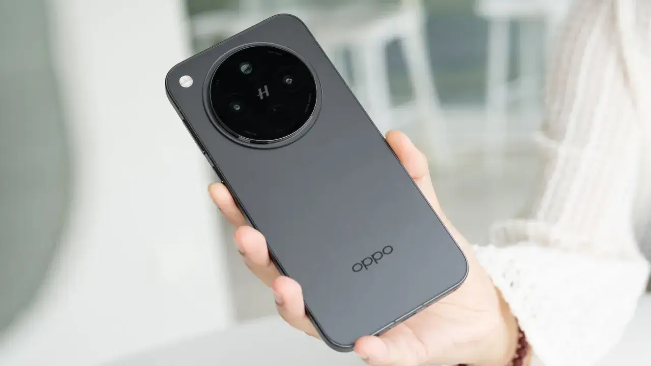 Mano sostiene un teléfono Oppo gris oscuro con un módulo de cámara circular.