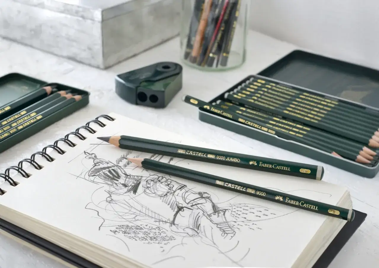 Ołówki Faber-Castell na szkicowniku. Rysik ołówka z grafitu i drewna, gotowy do tworzenia dzieł.