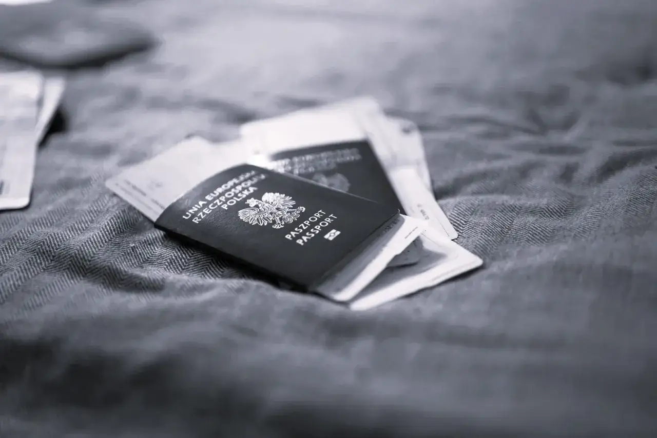 Polskie paszporty leżą na materiale. Długi pobyt za granicą? Czas na podróż!