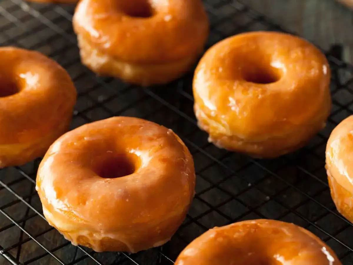 Deliciosos donuts caseros glaseados, recién hechos y enfriándose en una rejilla.
