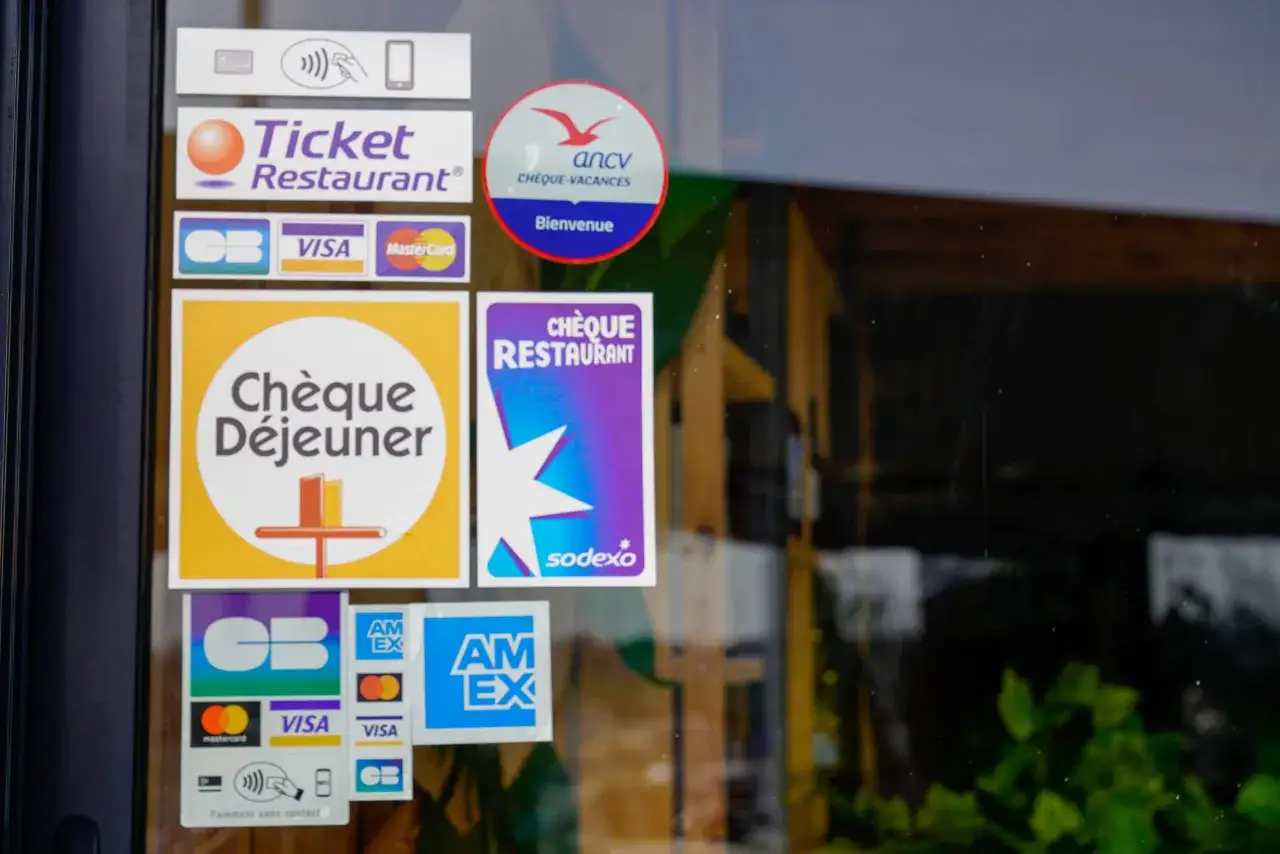 Autocollants sur une vitrine : Ticket Restaurant, Ch&egrave;que D&eacute;jeuner, Ch&egrave;que Restaurant Sodexo, ANCV Ch&egrave;ques-Vacances, CB, Visa, Mastercard, Amex. Id&eacute;al pour le t&eacute;l&eacute;travail et le ticket restaurant.