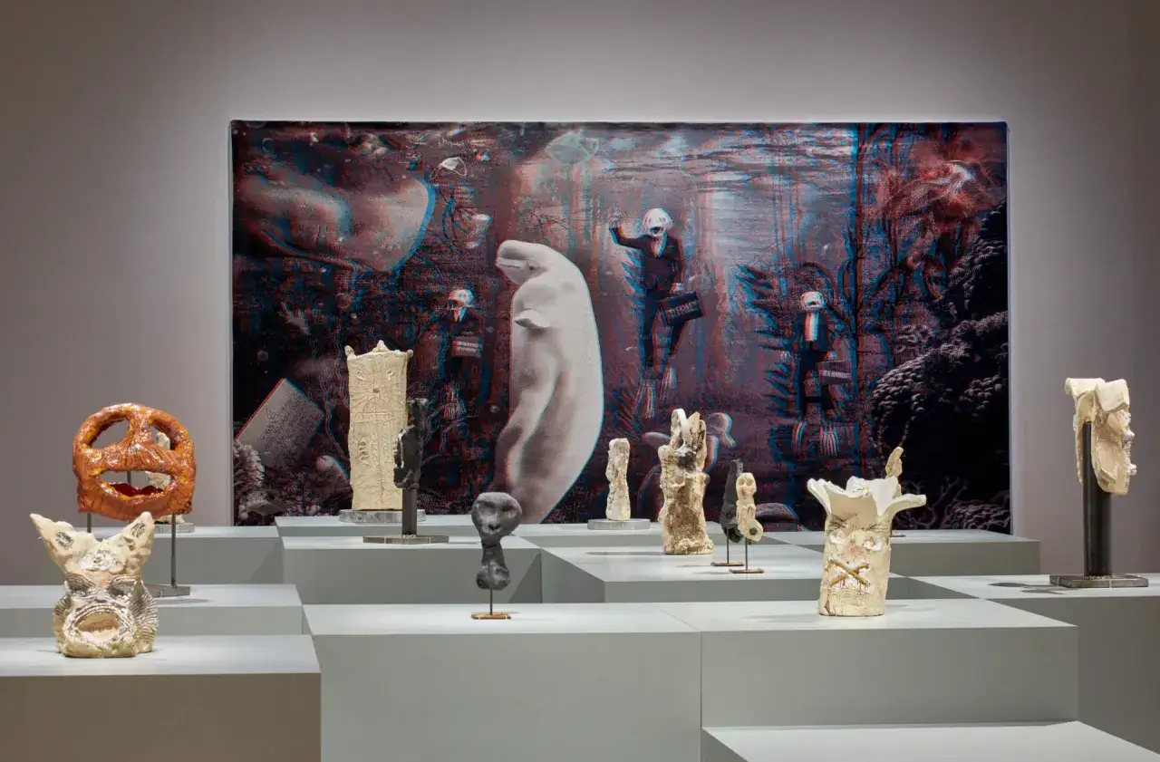 Sculptures and a surreal backdrop featuring a beluga whale and figures in suits, showcasing contemporary art trends.