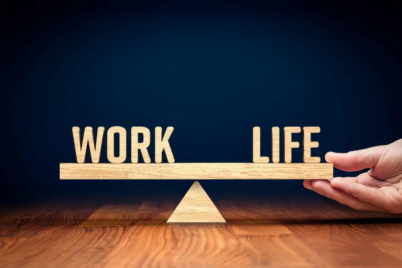 Drewniana waga symbolizuje work life balance. Litery 