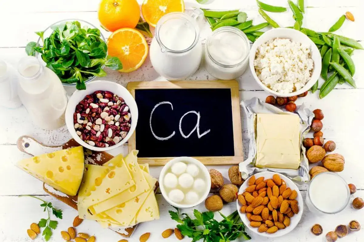 Eine **Calcium-Lebensmittel-Tabelle** mit Milchprodukten, Nüssen, Bohnen, Orangen und grünem Gemüse.