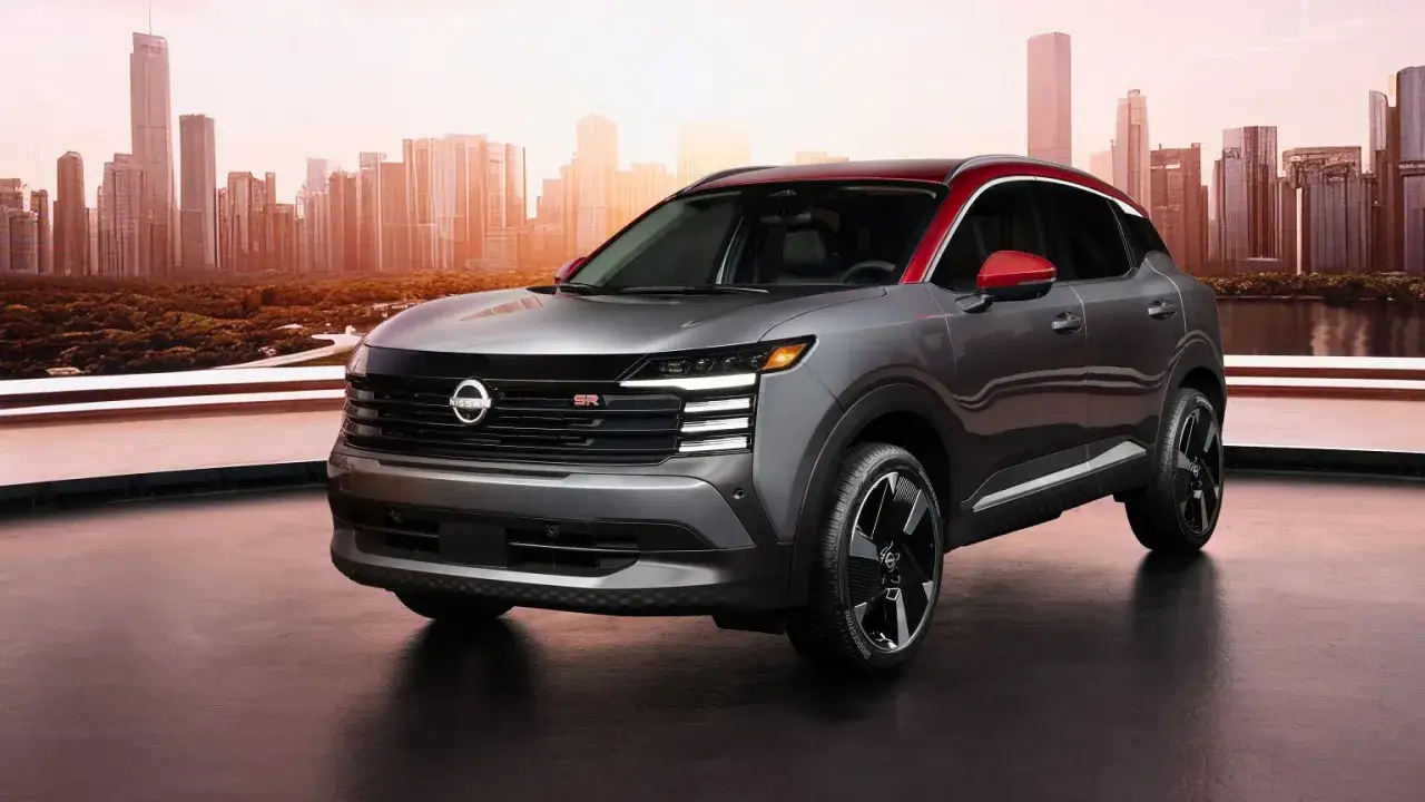 Nowy Nissan Kicks w szarym kolorze z czerwonym dachem i lusterkami, gotowy na miejskie przygody.