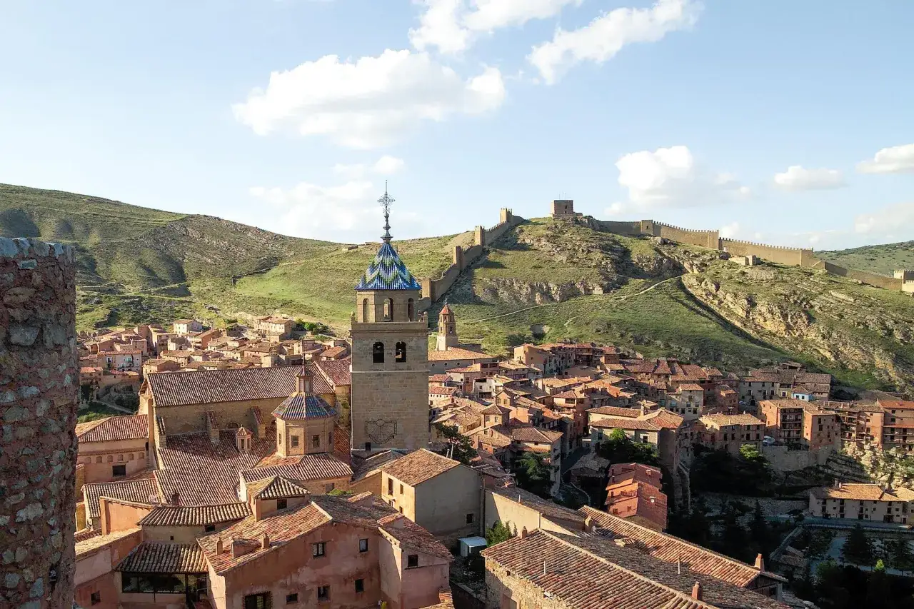 Albarrac&iacute;n, Spanien: malerisches Dorf mit roten D&auml;chern, Kirchturm und mittelalterlicher Stadtmauer auf einem H&uuml;gel.