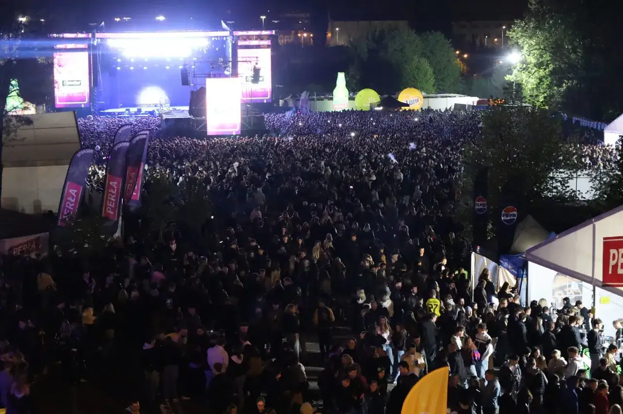 Tłum ludzi na koncercie podczas Juwenaliów Politechniki Lubelskiej. Na scenie światła, a wśród publiczności widać balony i banery sponsorów.